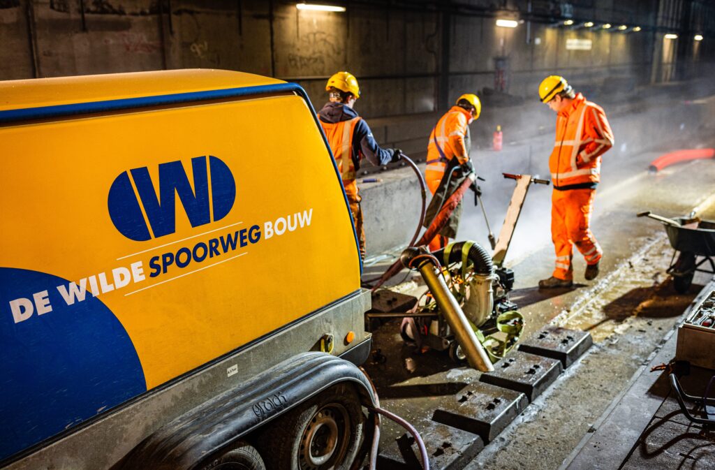 Werkzaamheden aan het spoor in een tunnel, met materieel van De Wilde Spoorwegbouw