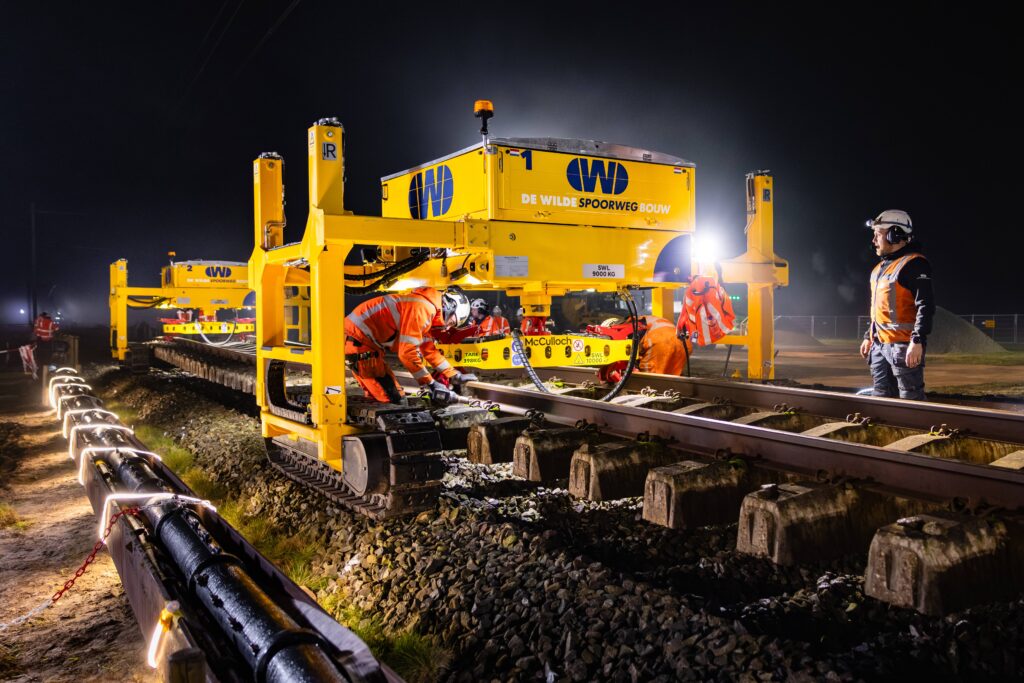 Spoorlegmachine van De Wilde Spoorwegbouw legt 's nachts nieuwe spoorstaven